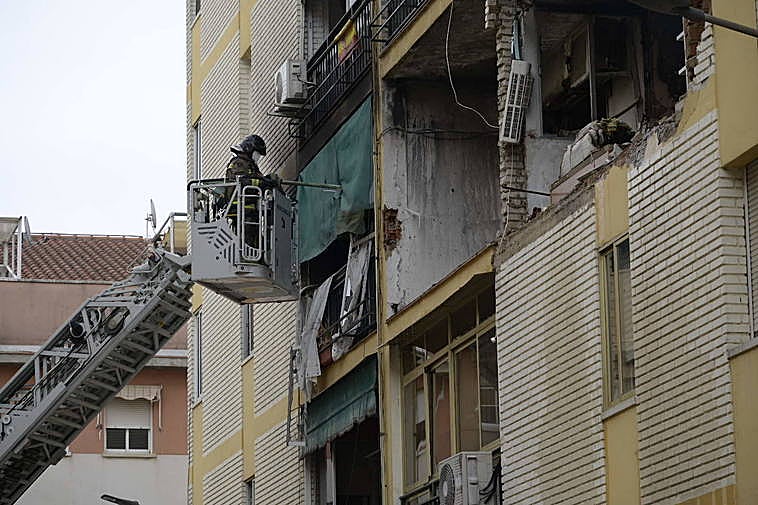 Los bomberos trabajan refrescando el edificio.