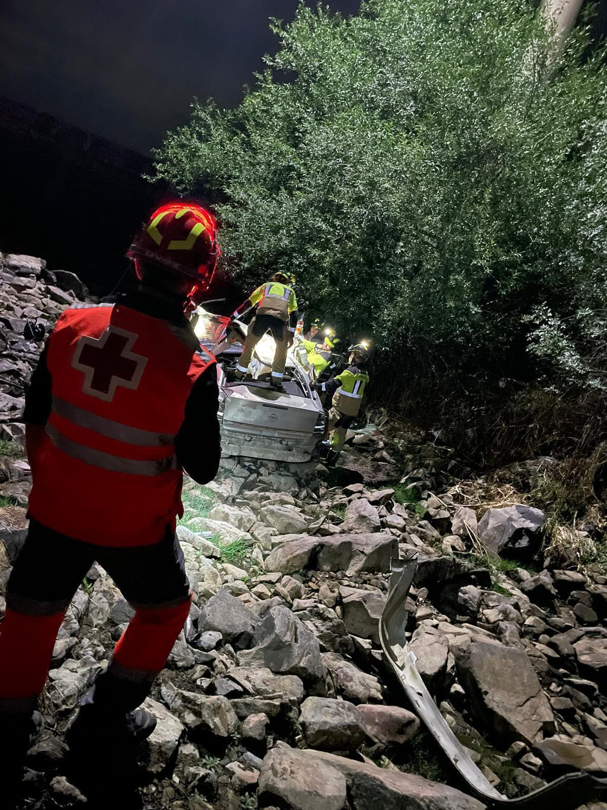 Un efectivo de Cruz Roja observa las tareas de rescate de los bomberos