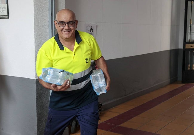 Un operario municipal lleva agua a la sede de la Escuela de Idiomas, que funciona como colegio electoral.