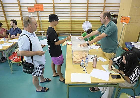 José MAnuel Rodríguez y su hijo votan en el colegio Enrique Segura antes de ir a la piscina