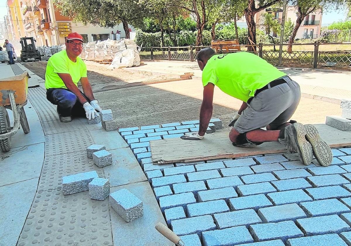 Dos operarios de Cubillana colocan los adoquines en el suelo de la calle Graciano.