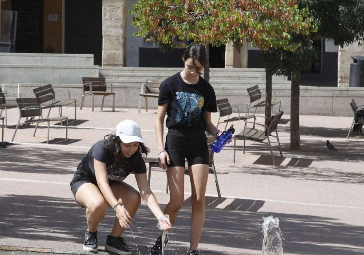 Dos jóvenes se refrescan en una fuente en Extremadura.