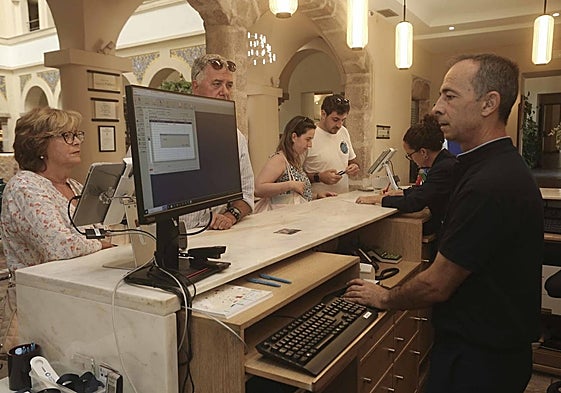 Dos empleados del hotel Ilunion Mérida Palace atienden a varios clientes en julio pasado.