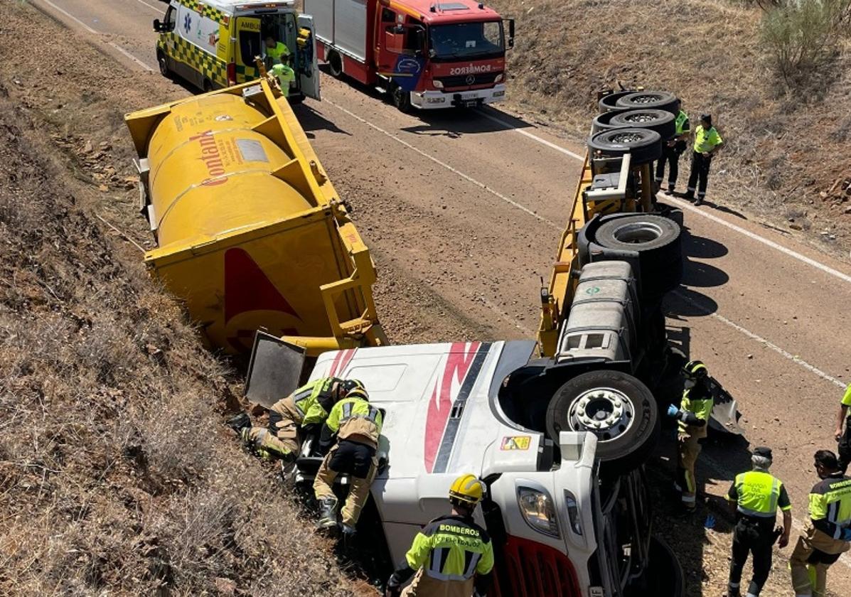 Bomberos de la Diputación de Badajoz intentan sacar al camionero, que quedó atrapado dentro de la cabina.