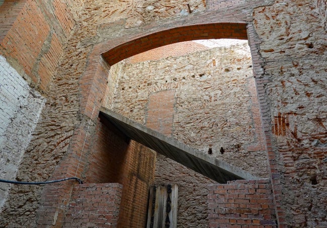 Las escaleras están sin lucir, el hueco espera el ascensor y las paredes están en ladrillo.