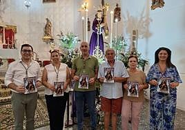 Algunos miembros de la Comisión de la Hermandad del Cristo con ejemplares de su nueva publicación, ayer ante su imagen titular.