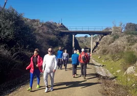 Caminantes en la antigua plataforma ferroviaria reconvertida en sendero para andar, correr o pedalear, a la altura de Plasencia.