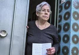 Juana Redondo en la puerta de su domicilio con la factura que le dejó el supuesto estafador.