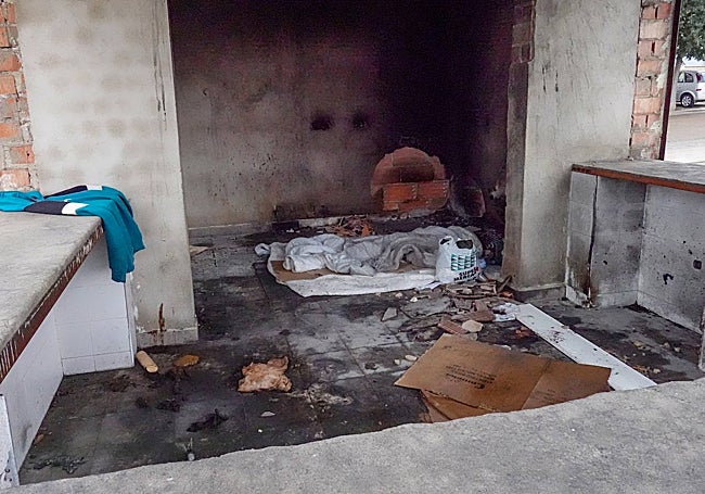 Interior del quiosco a medio construir y quemado, donde un chaval duerme cada día.