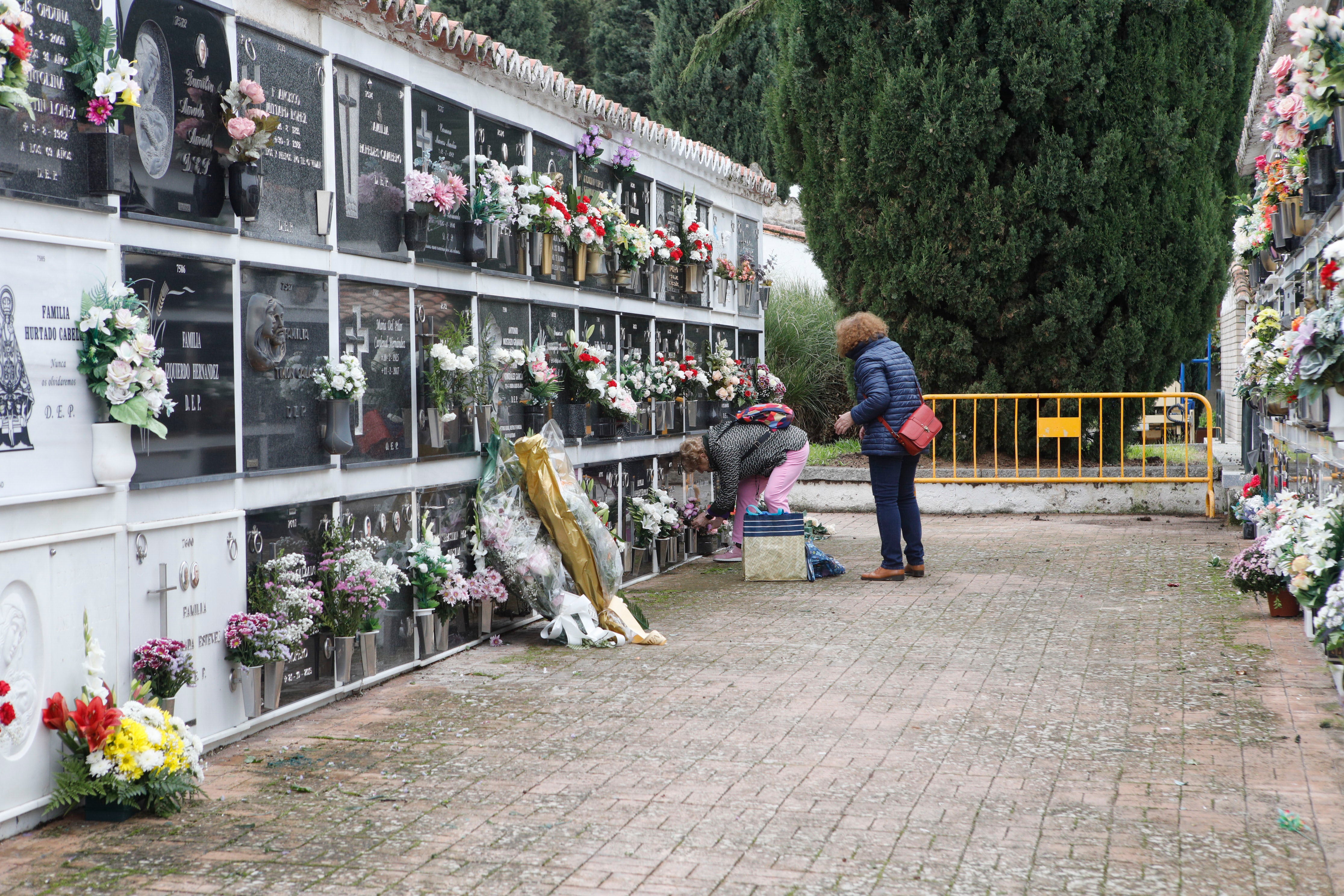 Familiares limpian y ornamentan las lápidas de sus seres queridos en Cáceres.