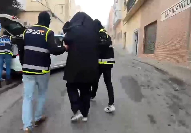 El imán de Badajoz es conducido al vehículo policial tras su detención.