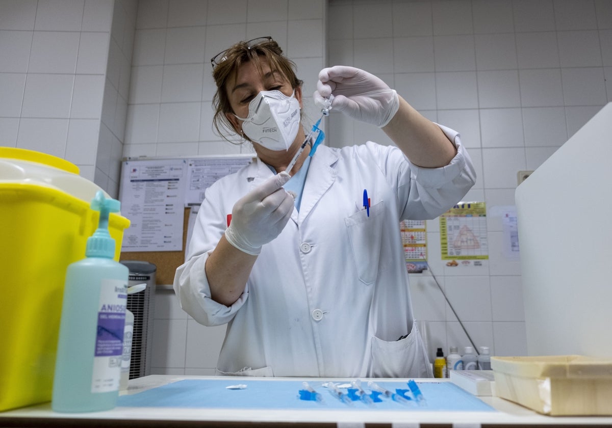 Una enfermera prepara una vacuna en un centro de salud.