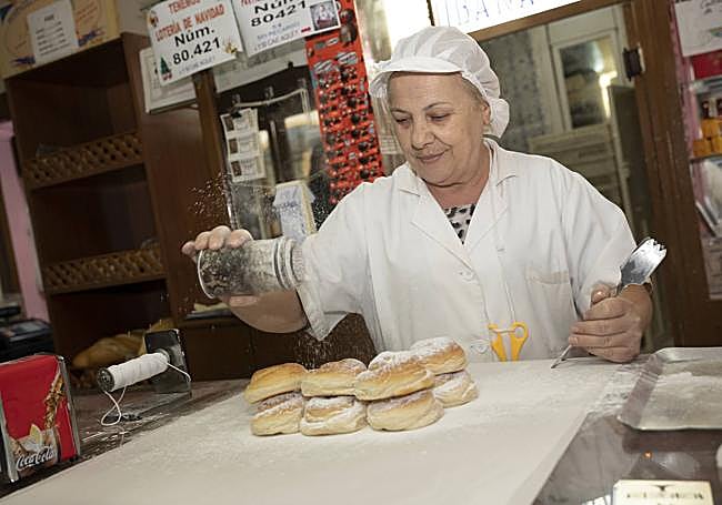 Maribel Margallo lleva 50 años de práctica rociando de azúcar glasé los bollos.
