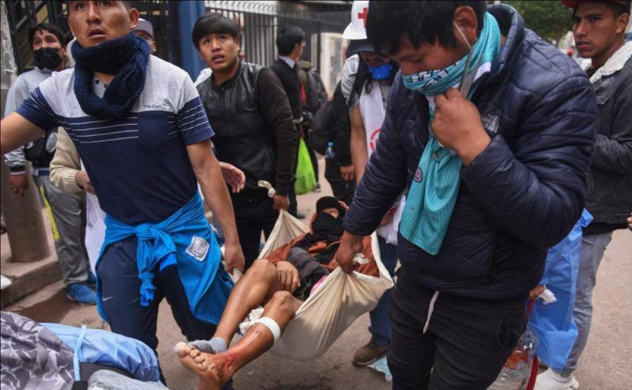 Un grupo de manifestantes retiran a un herido en las protestas, este jueves en Cuzco.