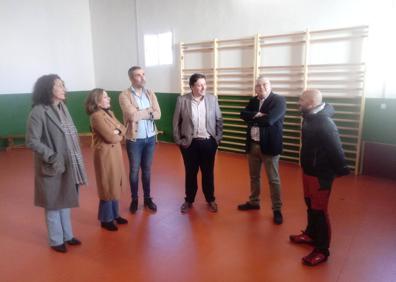 Imagen secundaria 1 - Arriba, el secretario general, flanqueado por el alcalde y miembros del equipo directivo del colegio de Alconchel; abajo, visitando las nuevas instalaciones para hacer deporte a cubierto y la biblioteca escolar. 