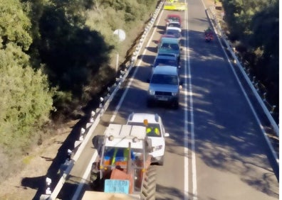 Imagen secundaria 1 - Mensajes contra el proyecto minero en la imagen superior. Abajo, algunos manifestantes con sus pancartas por la carretera y vehículos que han hecho el recorrido desde Holguera. 