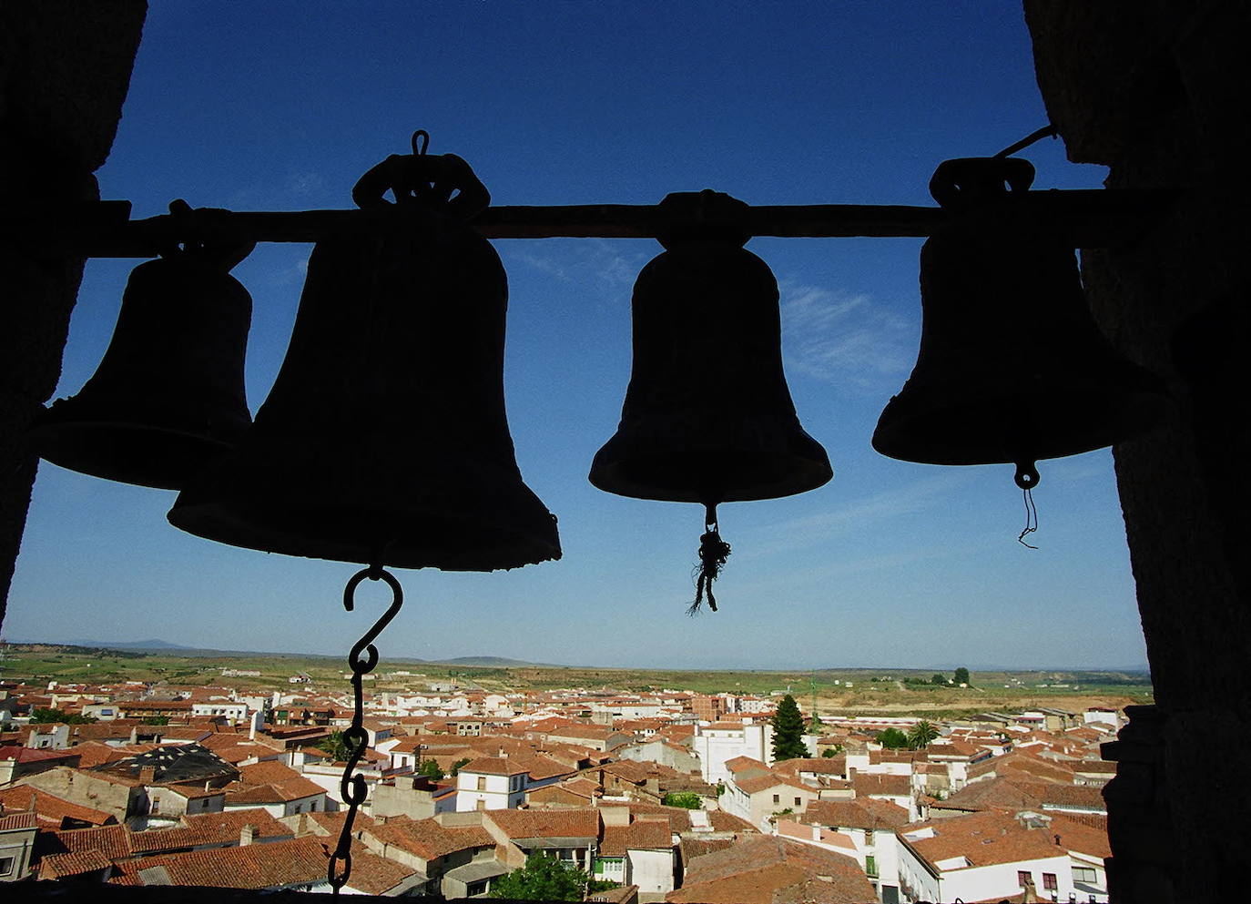 Campanas de la catedral de Coria con una imagen de la ciudad.