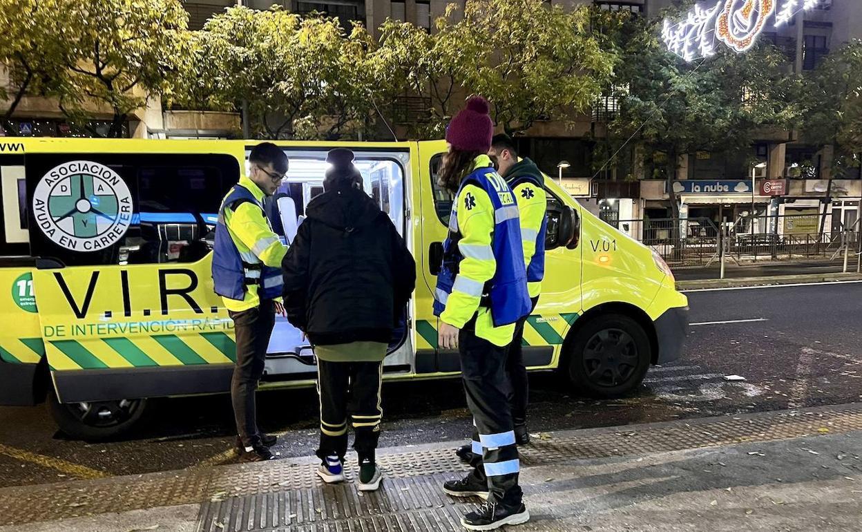 Voluntarios de DYA atienden a una persona durante la noche en una céntrica avenida de Cáceres. 