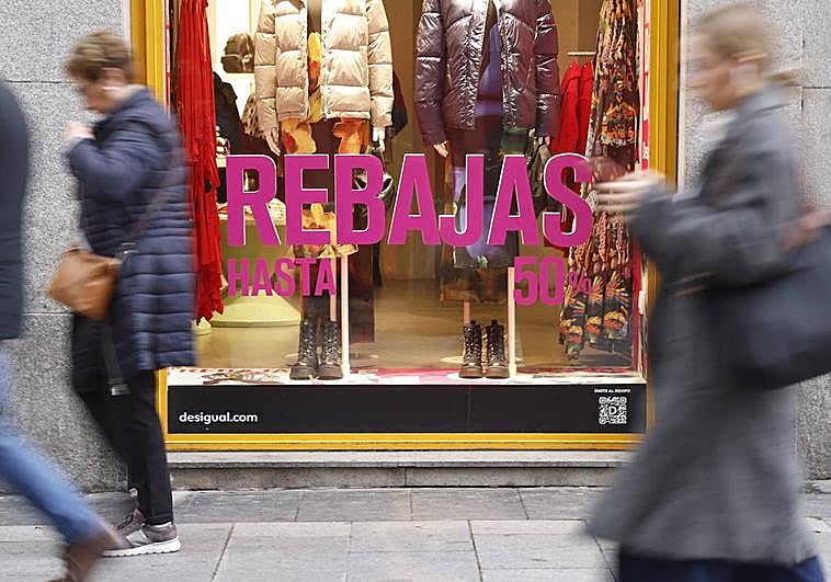 Vista de una calle comercial con los carteles de las rebajas.