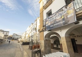 Una lona anuncia la apertura de la franquicia de hostelería en el local que ha dejado vacante 'Los Portales', en la parte baja de la Plaza Mayor de Cáceres.