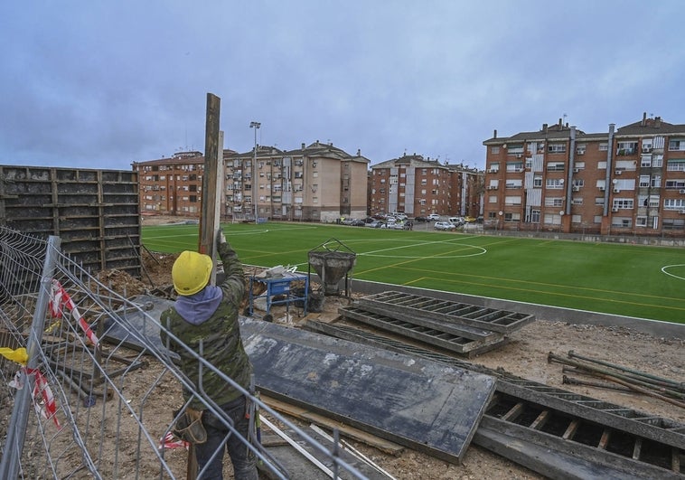 Un operario trabaja en el campo de fútbol, con el entorno por terminar, este lunes.