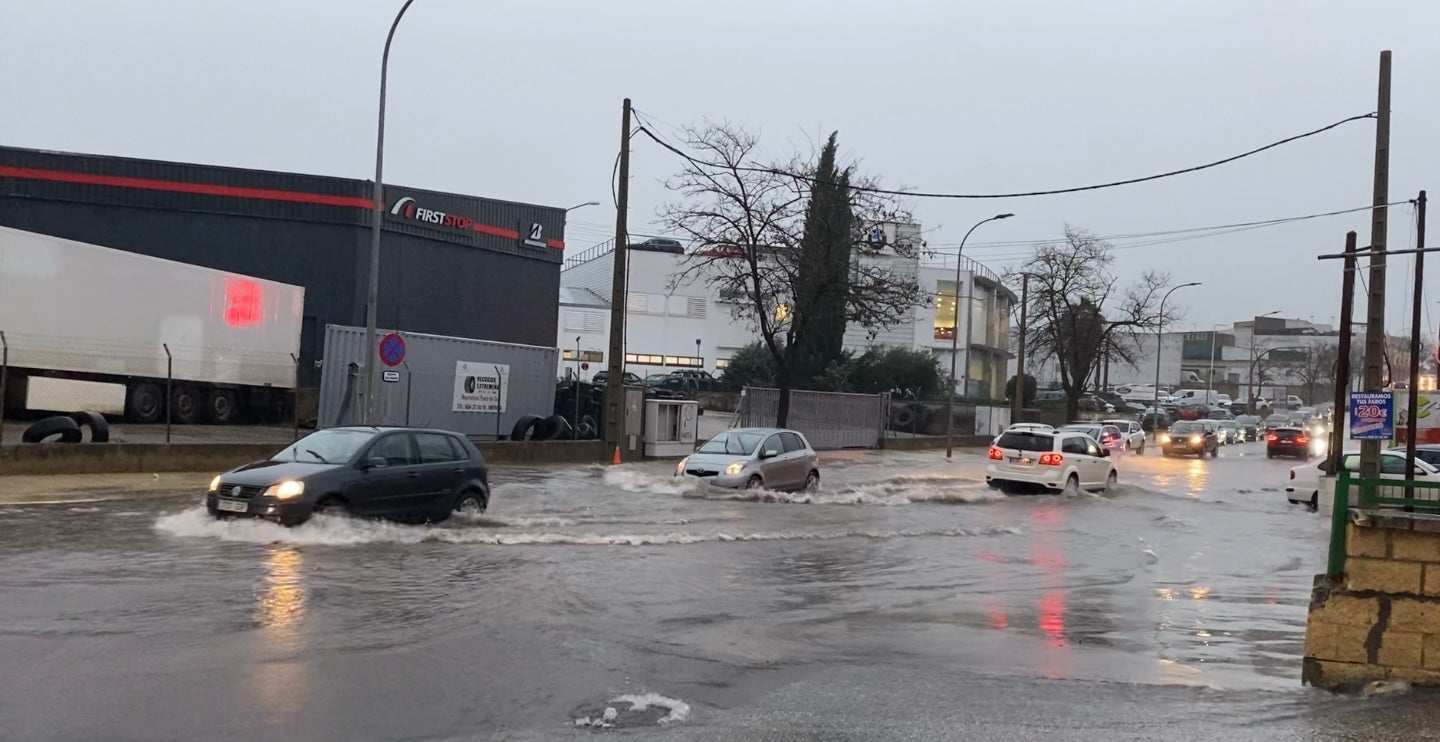 Coches cruzando una balsa de agua en la carretera de La Corte. 