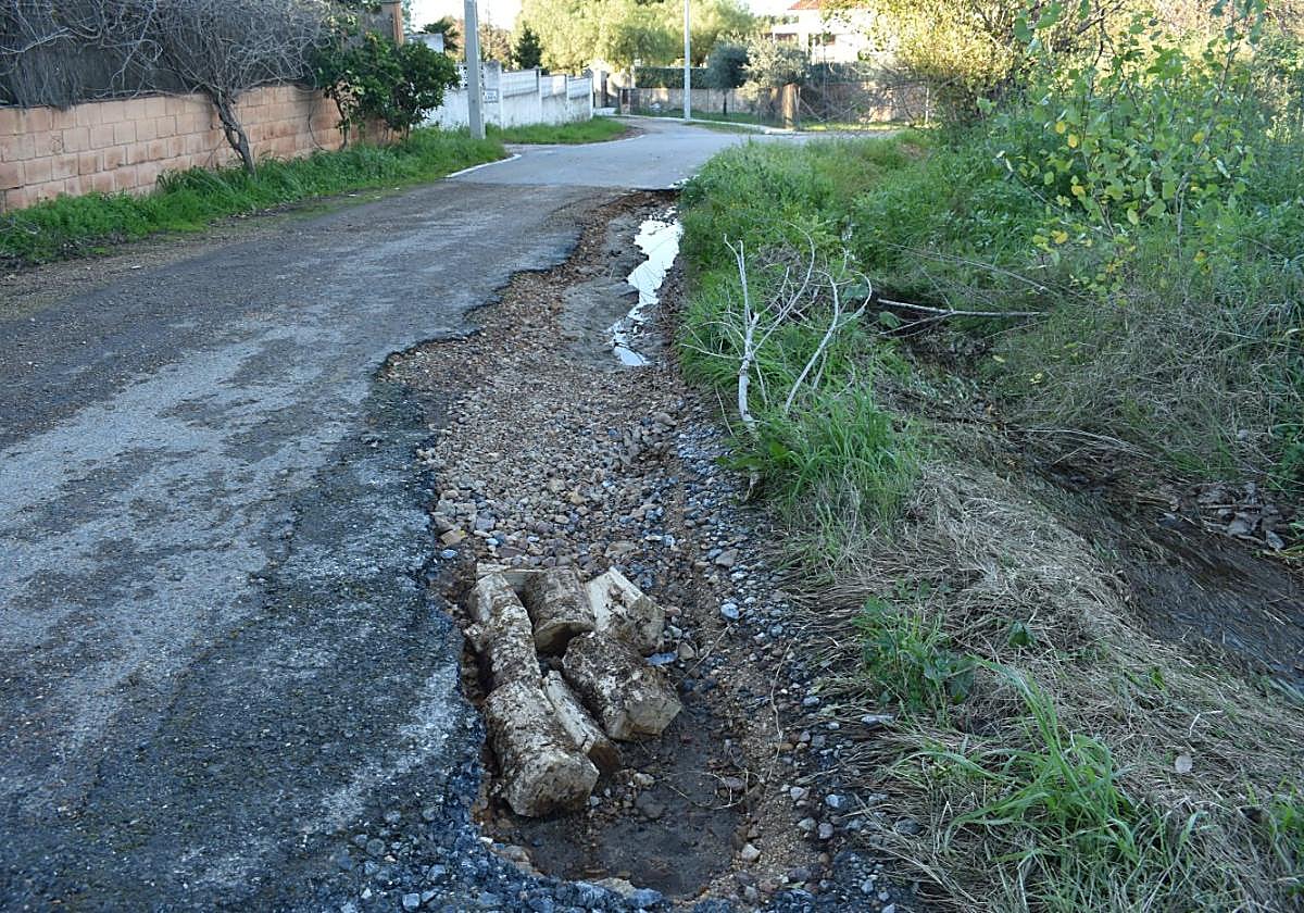 Calle Higuera de la Real, con un bache profundo por el que no pasa un coche.