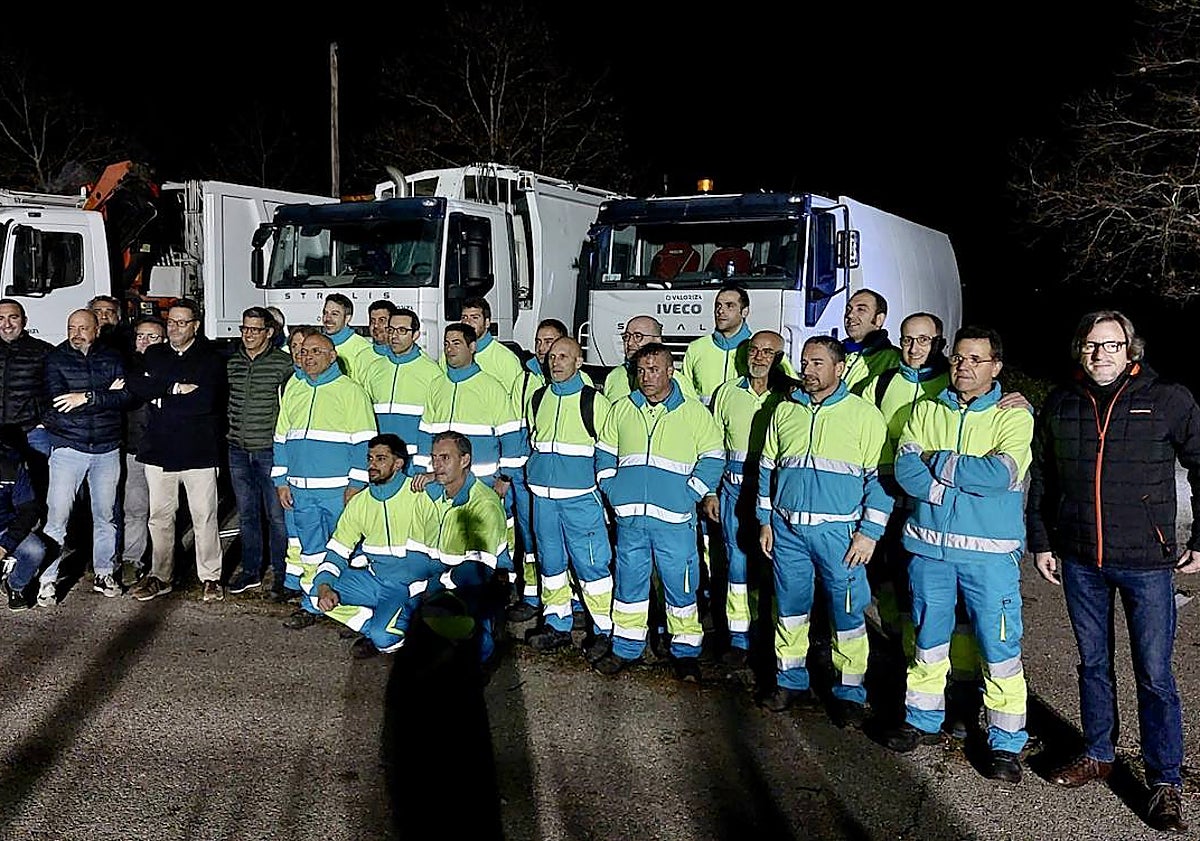 Imagen principal - Arriba, foto de familia de los responsables de la empresa y del Ayuntamiento con los trabajadores antes del inicio de la jornada de noche. Abajo, un camión de recogida luce el nombre de la nueva concesionaria. Sobre estas líneas, varios operarios con los uniformes de estreno. 