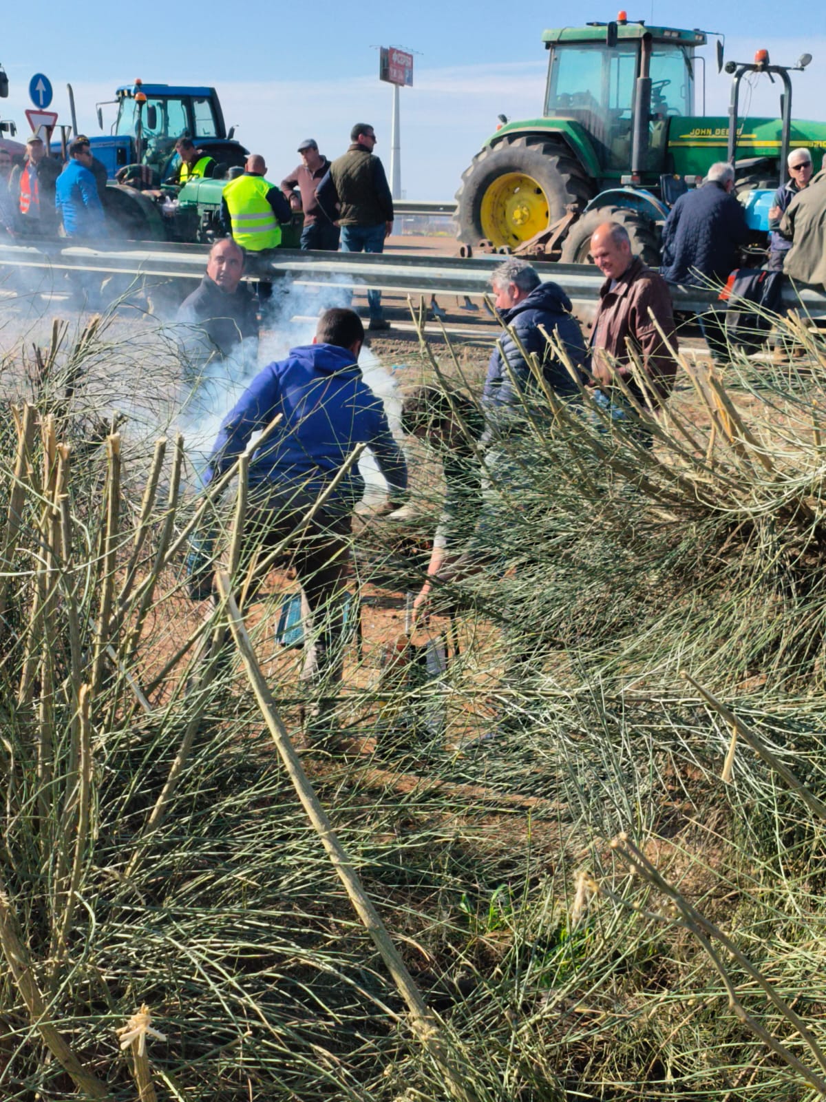 Manifestantes se disponen a encender una barbacoa junto a la A-66 para hacer algo de comer.