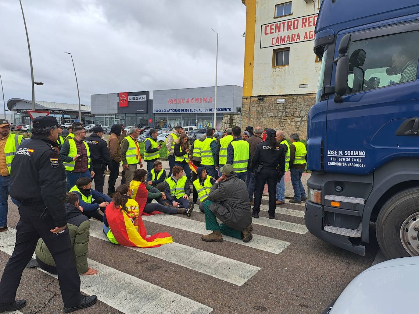 Manifestantes en la zona de la Consejería de Agricultura, en Mérida, donde se han sentado en el paso de peatones de la carretera llegando a cortar el tráfico 