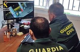 Guardias civiles durante el visionado de las cámaras de videovigilancia de la estación de servicio.