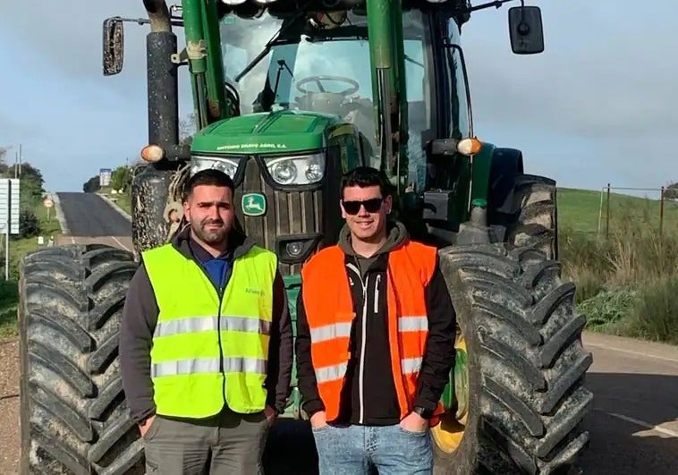 Dos agricultores cortando esta mañana la EX-107, a la altura de Villanueva del Fresno. 