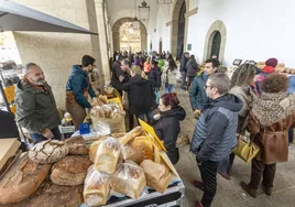 Cacereños y visitantes comprando en el biomercado de la Plaza Mayor de Cáceres este domingo.