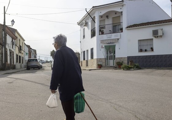 Una anciana paseando por Hinojal tras hacer la compra en una mañana tranquila.