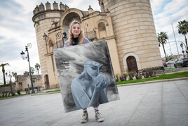 Carmen junto a Puerta Palmas con su lienzo 'La Creación'.