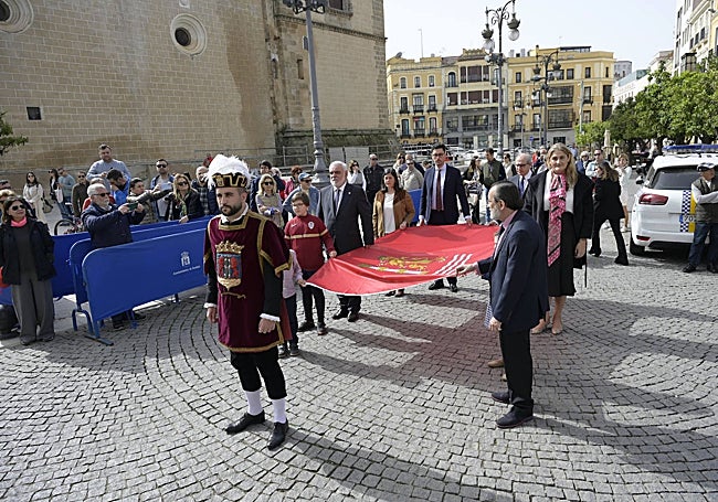Los miembros de la comisión que ha elegido la bandera y los niños participantes del acto portan la enseña hasta el Ayuntamiento.