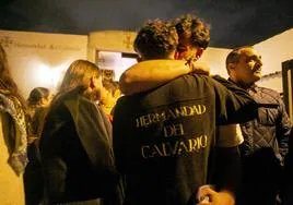 Dos jóvenes costaleros del Calvario se abrazan emocionados cuando se anuncia la suspensión.