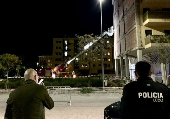 Pedro Muriel, concejal de Seguridad, sigue los trabajos de los bomberos junto a un agente.