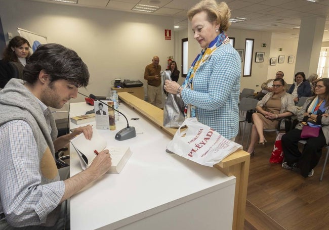 Goizueta firma un ejemplar a una asistente a la presentación.