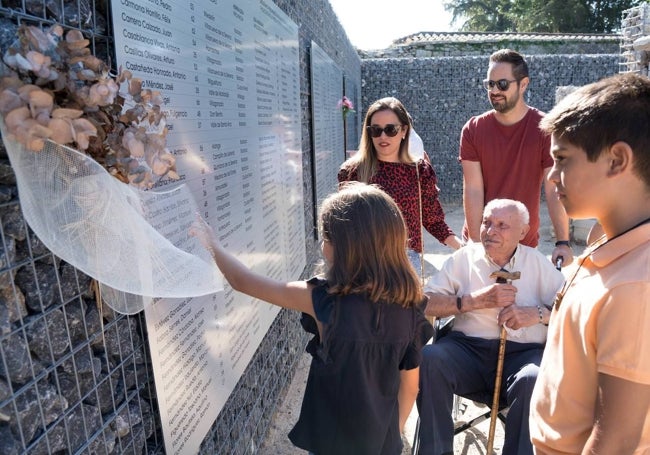 Miembros de la familia extremeña Del Amo, junto al mural de las víctimas franquistas del cementerio de Orduña.