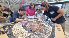 Una alumna trabajadora de Barraeca muestra a los visitantes la réplica de Medusa en la que pueden colaborar