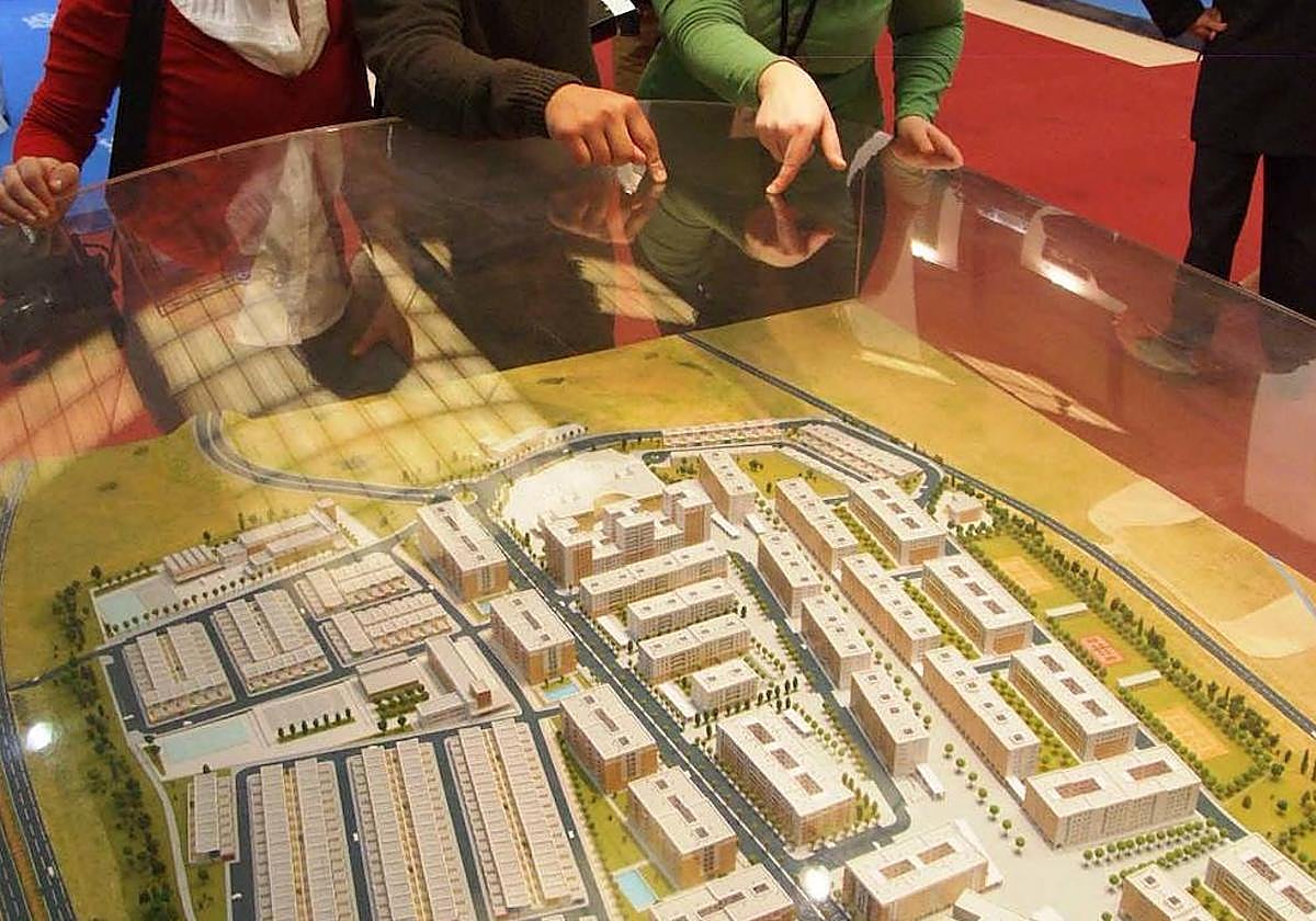 Imagen de archivo de visitantes en la Ficon, señalando una maqueta expuesta en un stand.