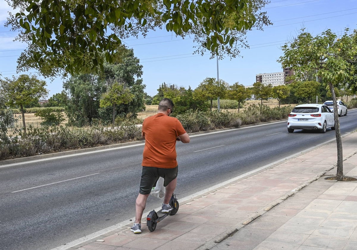 Un hombre circula en patinete por el Puente Real hacia la rotonda de José Miguel Benegas en agosto.