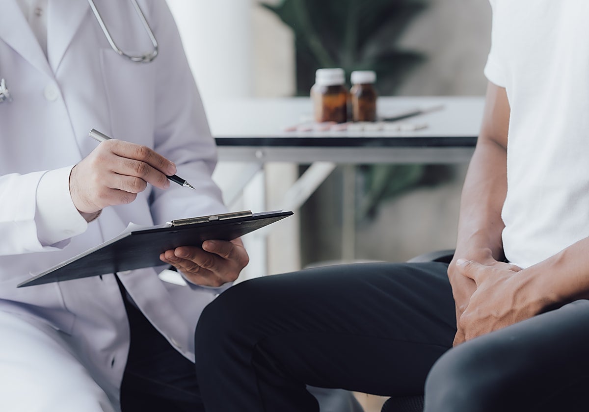 Un médico atiende a un paciente en consulta.
