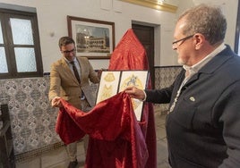 El concejal de Cultura y el mayordomo de la cofradía muestran el boceto del manto del centenario.