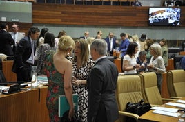 María Guardiola habla con los consejeros Elena Manzano y Manuel Martín Castizo, en los momentos previos al pleno.