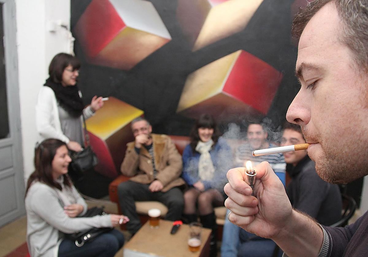 Imagen de archivo de un fumador en una reunión de amigos.