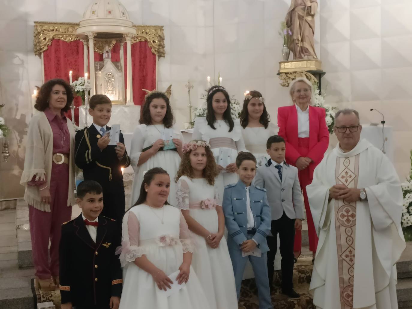 Grupo de niños y niñas que este año han hecho la Primera Comunión, junto al párroco y las catequistas.