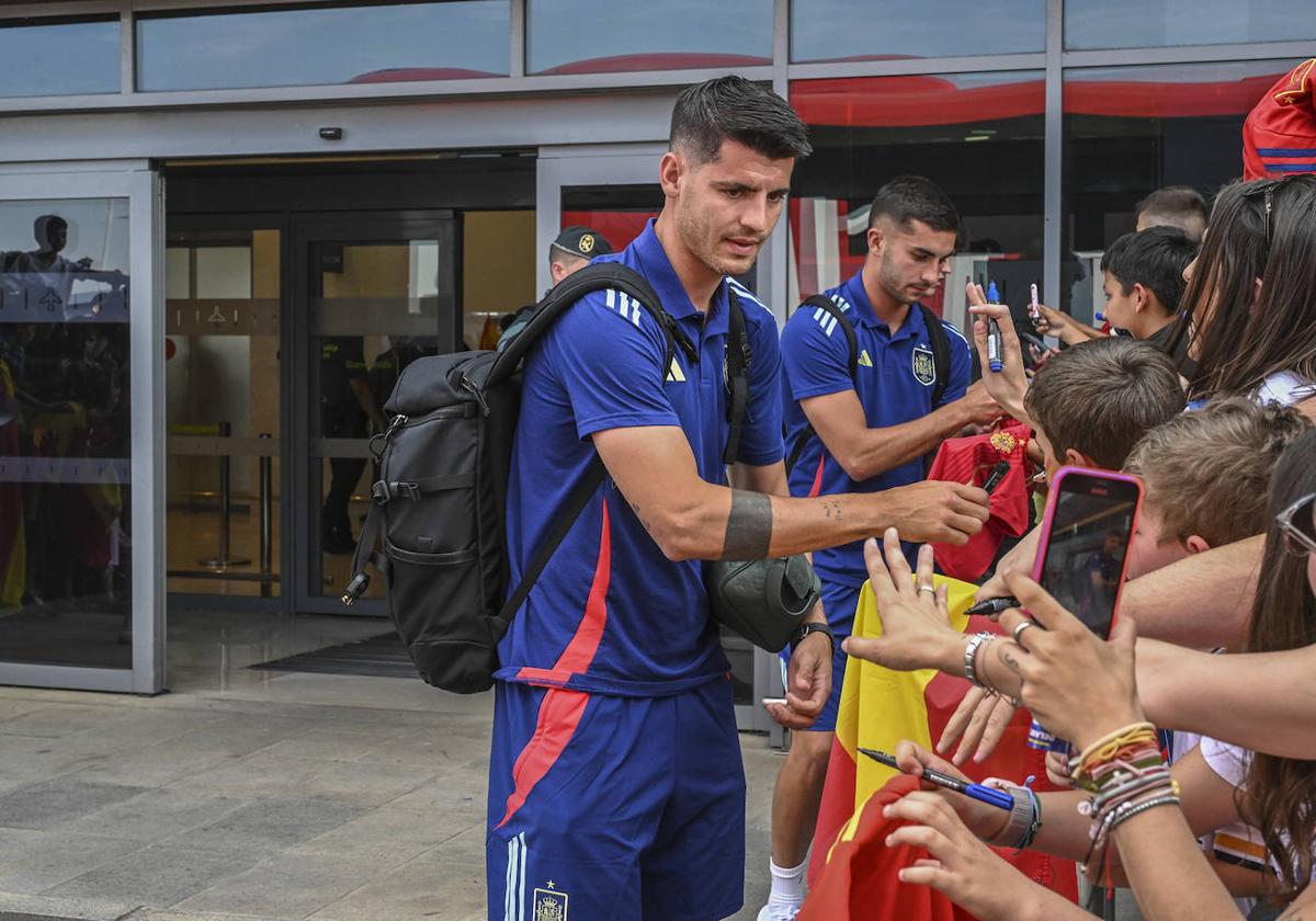 Morata y Ferran Torres firmando autógrafos a la salida del aeropuerto.