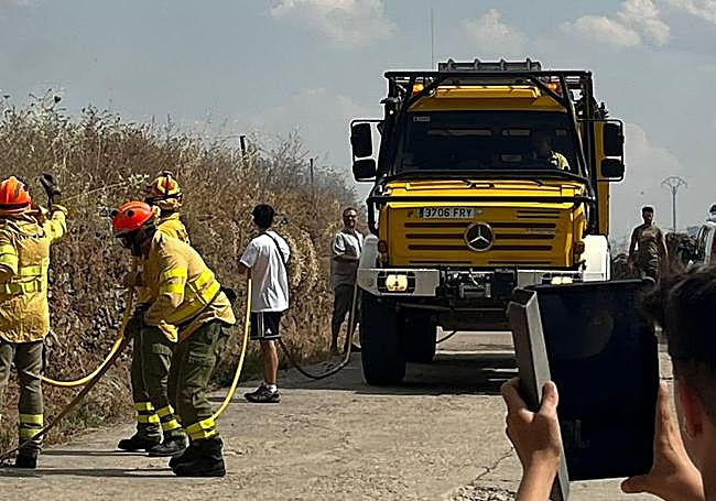 Bomberos del Infoex y vecinos, en las labores de extinción de las llamas.